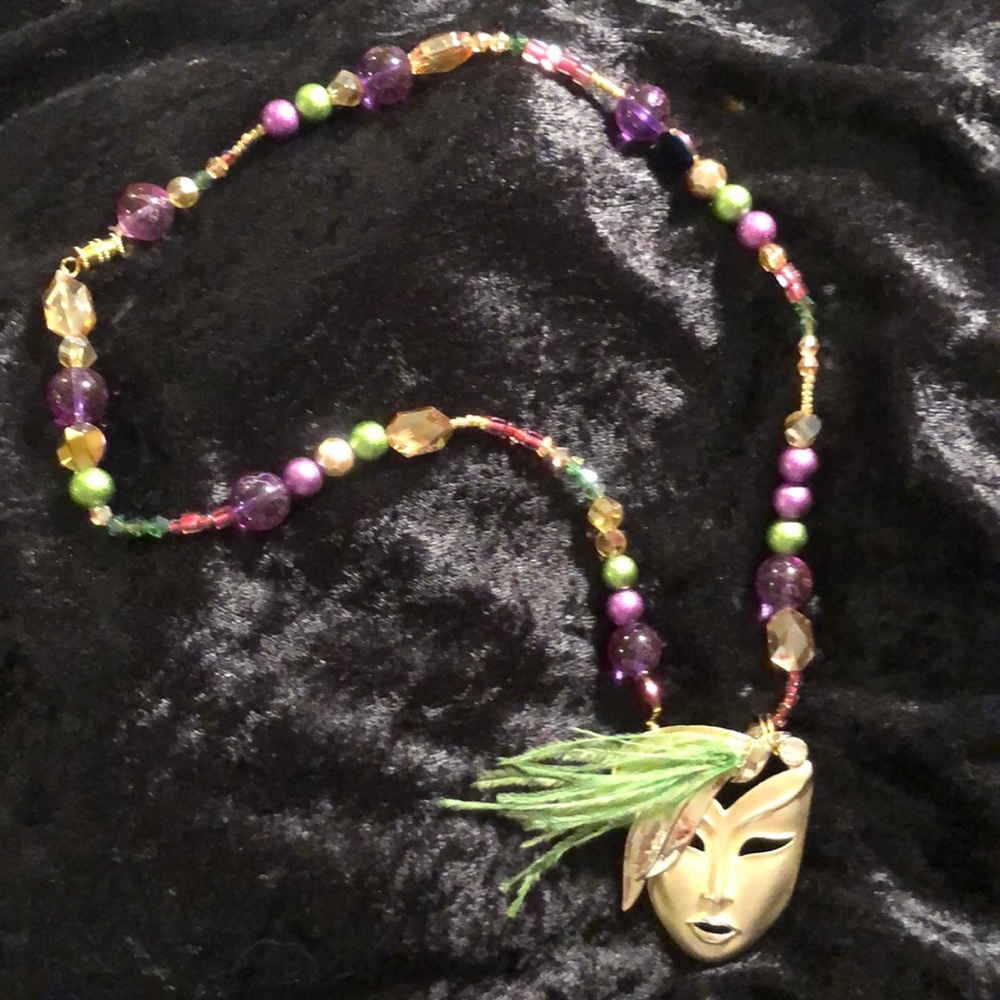 Mardi Gras necklace with feathers on face